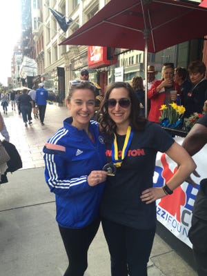 Seen here in 2017, Amy and Ali Pepe get together near the Boston Marathon finish line. Amy put her Marathon finisher's medall around Ali's neck, saying 'You're up next!' [Courtesy Photo]