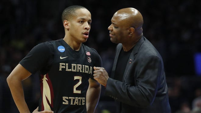 Florida State guard CJ Walker talks with coach Leonard Hamilton during last week's NCAA Tournament game against Michigan. Walker has been granted his release to transfer by FSU. [AP Photo/Jae Hong]