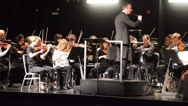 Wesley Schulz, Associate Conductor, leads musicians from the NC Symphony as they perform for Lenoir County school children Tuesday at the Kinston High School Performing Arts Center. [Janet S. Carter / The Free Press]