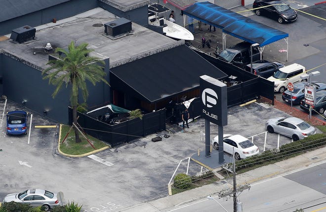FILE - In this June 12, 2016 file photo, law enforcement officials work at the Pulse nightclub in Orlando, Fla., following a mass shooting. The widow of the gunman who killed dozens of people at the Pulse nightclub in Orlando is going on trial Wednesday, March 14, 2018, in federal court. Thirty-one-year-old Noor Salman is charged with aiding and abetting her deceased husband Omar Mateen in planning the 2016 attack on the Pulse nightclub. (AP Photo/Chris O'Meara, File)
