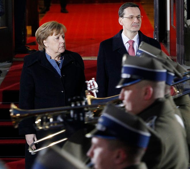 Poland's Prime Minister Mateusz Morawiecki,right, greets German Chancellor Angela Merkel before talks on European Union future and security and on bilateral ties at his office in Warsaw, Poland, Monday, March 19, 2018. (AP Photo/Czarek Sokolowski)