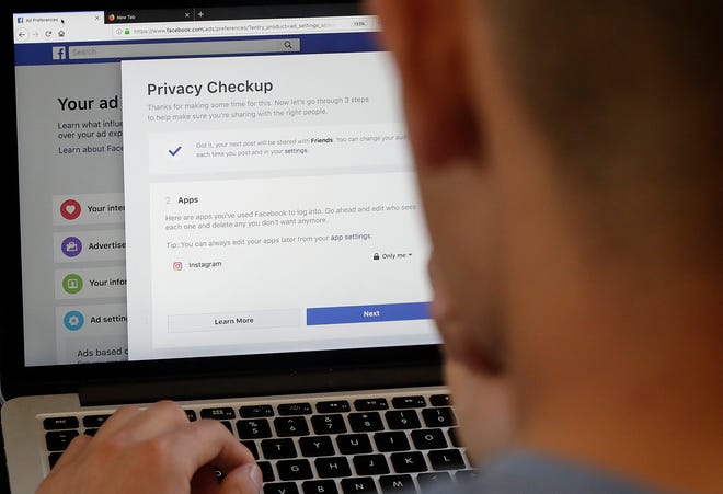 In this March 26, 2018 photo, a man poses for photos in front of a computer showing Facebook ad preferences pages in San Francisco. Facebook is giving its privacy tools a makeover as it reels from criticisms over its data practices and faces tighter European regulations in the coming months. (AP Photo/Jeff Chiu)