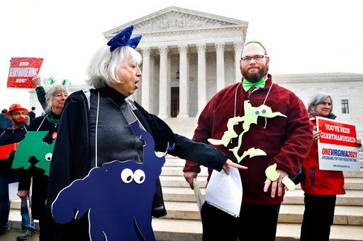 Helenmary Ball, left, of Calvert County, Md., as "Maryland District 5," points toward the separated area of Maryland District 3, being represented by Bobby Bartlett, right, as nonpartisan groups against gerrymandering protest in front of the Supreme Court, Wednesday, March 28, 2018, in Washington where the court will hear arguments on a gerrymandering case. The Supreme Court is taking up its second big partisan redistricting case of the term amid signs the justices could place limits on drawing maps for political gain. T(AP Photo/Jacquelyn Martin)