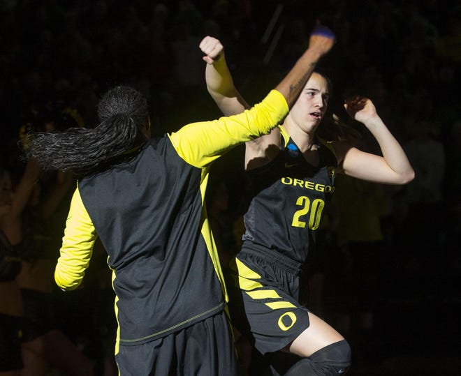 Oregon's Oti Gildon (left) and Sabrina Ionescu celebrate during team introductions before their Elite Eight game against Notre Dame. (Chris Pietsch/The Register-Guard)