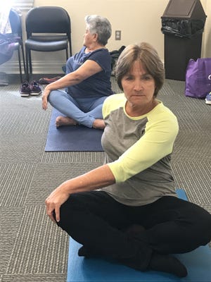 Debbie Greene keeps limber with the free yoga class at Mauney Memorial Library in Kings Mountain on Monday. [Joyce Orlando/The Star]