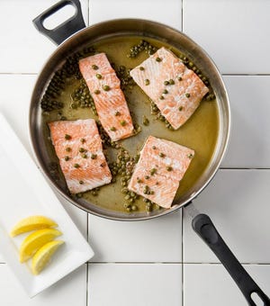 Salmon fillets cooked with anchovy butter and capers. [Erie Times-News]