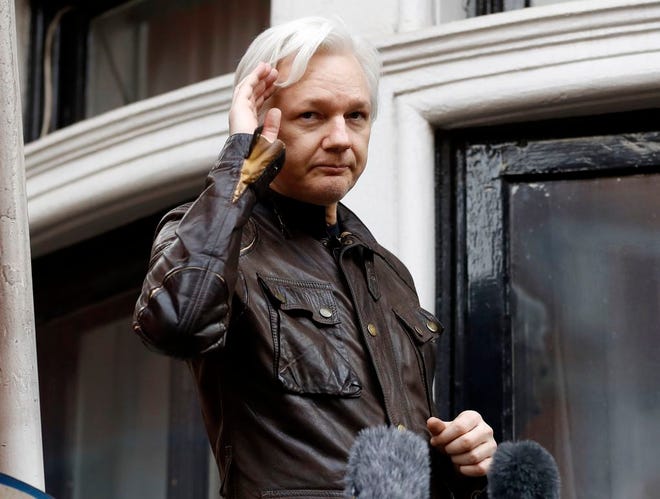 WikiLeaks founder Julian Assange greets supporters from a balcony of the Ecuadorian embassy in London on May 19, 2017. (AP Photo/Frank Augstein, File)