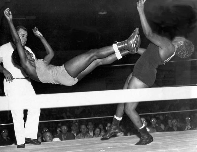 Ethel Johnson, left, delivers a dropkick to her opponent (and sister), Babs Wingo, during a match in the 1950s.