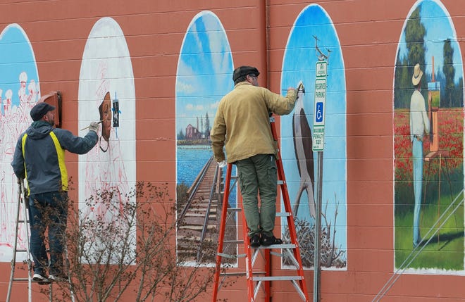 Local artists Jeremy Sams and Bernie Rosage continue work on murals alongside the Jacksonville Council for the Arts Building in downtown Jacksonville. Depicting various scenes of life in the area, the murals are anticipated to be completed near the end of March. [John Althouse / The Daily News]