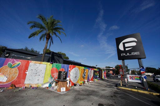 FILE - In this Nov. 30, 2016 file photo, artwork and signatures cover a fence around the Pulse nightclub, scene of a mass shooting, in Orlando, Fla. Jurors in the federal trial of Noor Salman, the Pulse nightclub gunman's widow, have gotten a look inside his Florida condo through crime scene photos taken as FBI agents searched the home. They also saw some of her husband Omar Mateen's web browsing history Tuesday, March 20, 2018, including beheading videos created by the Islamic State group Mateen had pledged allegiance to. Salman is accused of aiding and abetting her husband in the 2016 attack that left 49 people dead. (AP Photo/John Raoux)
