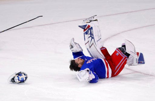 New York Rangers goaltender Henrik Lundqvist loses his mask as he hits the ice after being upended on a play during the third period of the team's NHL hockey game against the Columbus Blue Jackets, Tuesday, March 20, 2018, in New York. The Blue Jackets won 5-3. (AP Photo/Julie Jacobson)
