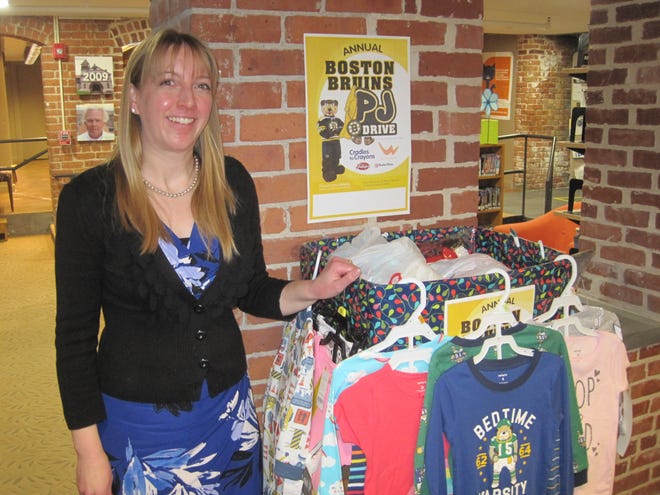 Kate Schreitmueller, the new Reference, Information and Technology Services Librarian at the Ames Free Library, with the box of donated pajamas for this year's Boston Bruins PJ Drive. [Courtesy photo]