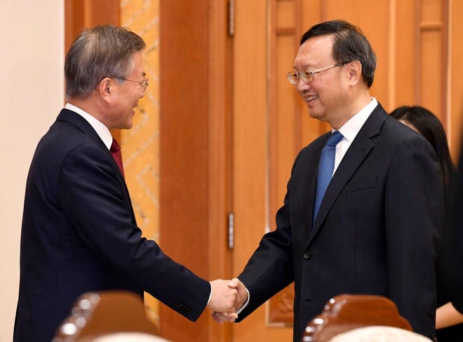 South Korean President Moon Jae-in, left, shakes hands with Chinese State Councilor Yang Jiechi at the Presidential Blue House in Seoul, South Korea Friday. Yang is spending two days in Seoul briefing South Korean officials on the results of the talks between North Korean leader Kim Jong Un and Chinese counterpart Xi Jinping. Yang met with presidential national security director Chung Eui-yong on Thursday and met President Moon on Friday.
