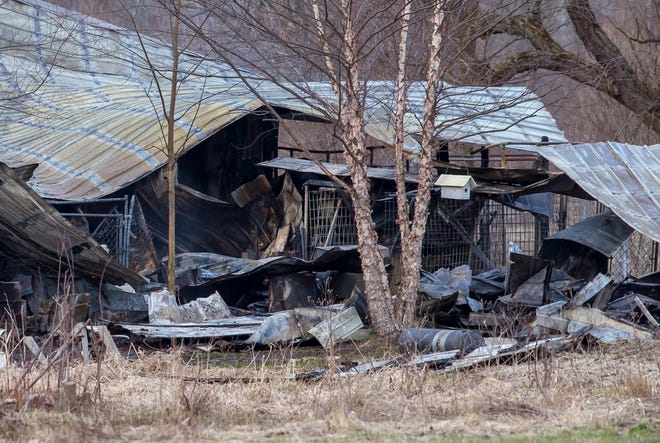 Charred debris lies in the aftermath of a fire at a boarding kennel in Fruitport Township, Mich., on Friday, March 30, 2018. Authorities say over two dozen dogs are believed to have died in the early morning fire in western Michigan. (Cory Morse /The Grand Rapids Press via AP)