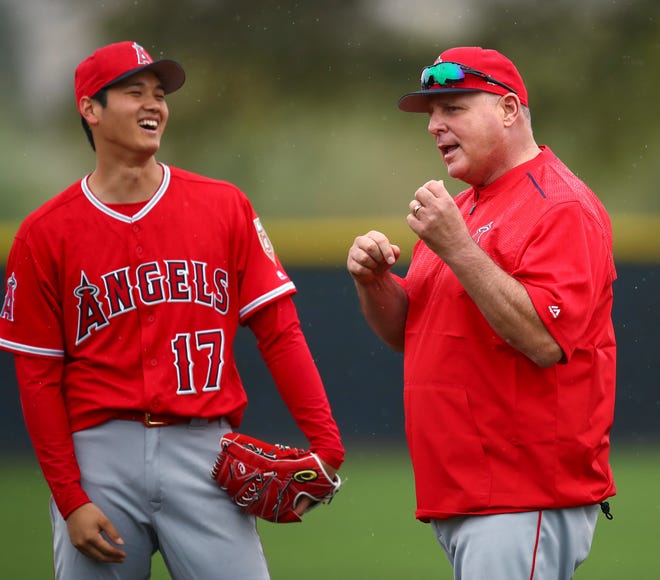 Angels skipper Mike Scioscia (right) hands the ball to rookie Shohei Ohtani (left) Sunday in Oakland. [ASSOCIATED PRESS FILE]