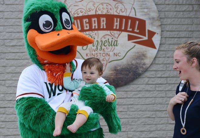 Gordon Kelly, 10-months-old, grabs DEWD's bill as his mother Mary looks on Friday outside Sugar Hill Pizzeria on Herritage Street in Kinston. [Janet S. Carter / The Free Press]