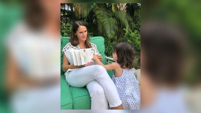 Abby Kunhardt Zinn, reads her great-grandmother’s book ‘Pat the Bunny’ to her nearly 2-year-old daughter Kick at their West Palm Beach home. (Photo by Sarah Yansura Cooke)