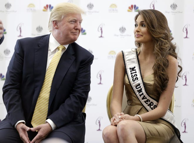 Donald Trump and Miss Universe, Gabriela Isler of Venezuela, talk during a news conference in 2014. [AP Photo/Wilfredo Lee.