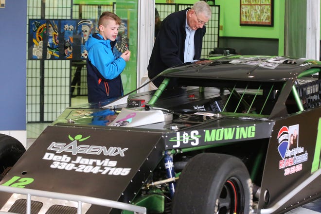 Gene Dummermuth of Dover and Matthew Knight, 11, of Dover, check out one of the cars on display during the Midvale Speedway Car Show at New Towne Mall in New Philadelphia Saturday. The racing season begins Saturday, April 14. (TimesReporter.com / Pat Burk)