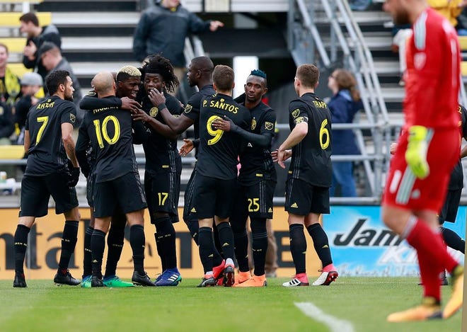 Columbus Crew players celebrate a goal by forward Gyasi Zerdes (11) against Vancouver Whitecaps goalkeeper Stefan Marinovic (1) in the first half of an MLS soccer game in Columbus, Ohio, Saturday, March 31, 2018. (Brooke LaValley)