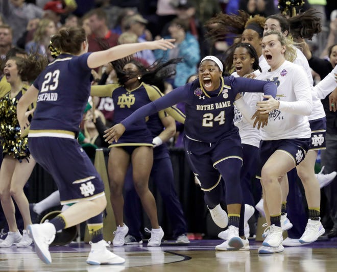 Notre Dame's Arike Ogunbowale (24) is congratulated by teammate Jessica Shepard (23) after sinking a 3-point basket to defeat Mississippi State 61-58 in the final of the women's NCAA Final Four college basketball tournament, Sunday, April 1, 2018, in Columbus, Ohio. (AP Photo/Tony Dejak)