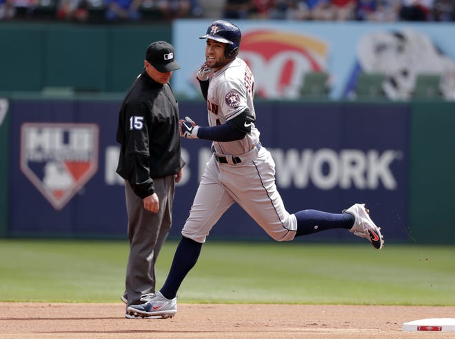 Second base umpire Ed Hickox, left, watches as Houston Astros' George Springer, right, rounds second after hitting a solo home run off Texas Rangers' Cole Hamels on a lead at-bat in the first inning of a baseball game in Arlington, Texas on Thursday. [AP Photo/Tony Gutierrez]