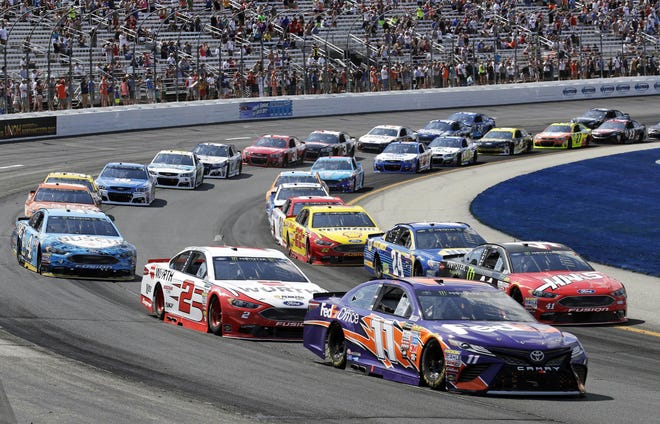 In this July 16, 2017 file photo, driver Denny Hamlin (11) leads the pack during the NASCAR Cup Series auto race at the New Hampshire Motor Speedway in Loudon. Owners of the speedway face an April 2018 court challenge over plans to bring in a country music festival to the venue after it lost a top-tier NASCAR race to Las Vegas. [AP Photo/Charles Krupa]