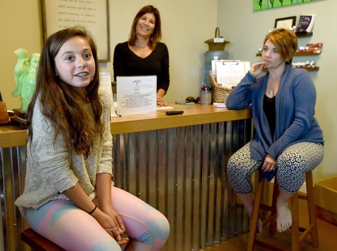Molly Stockings, left, talks at Yoga Junkie in Niceville where she is taking classes to be a yoga instructor. She is pictured with Yoga Junkie owners Teri Sarkozy, middle, and Kristy Souto in the studio. [NICK TOMECEK/DAILY NEWS]