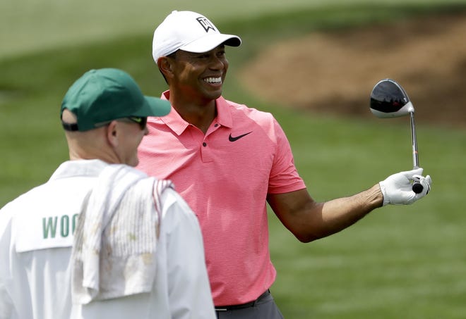 Tiger Woods smiles on the driving range during practice for the Masters at Augusta National Golf Club on Monday. [THE ASSOCIATED PRESS]