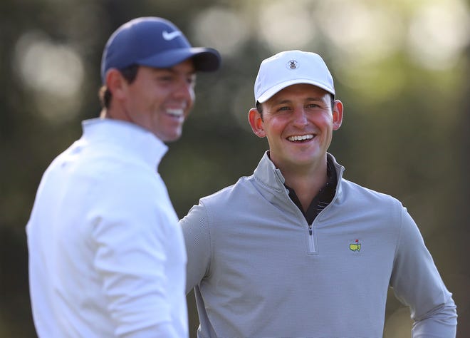 Matt Parziale, right, the U.S. Mid-Amateur champion who works as a firefighter in his hometown in Massachusetts, shares a laugh with Rory McIlroy on the first green during a practice round for the Masters golf tournament at Augusta National Golf Club on Monday in Augusta, Ga. [Curtis Compton/Atlanta Journal-Constitution via AP]