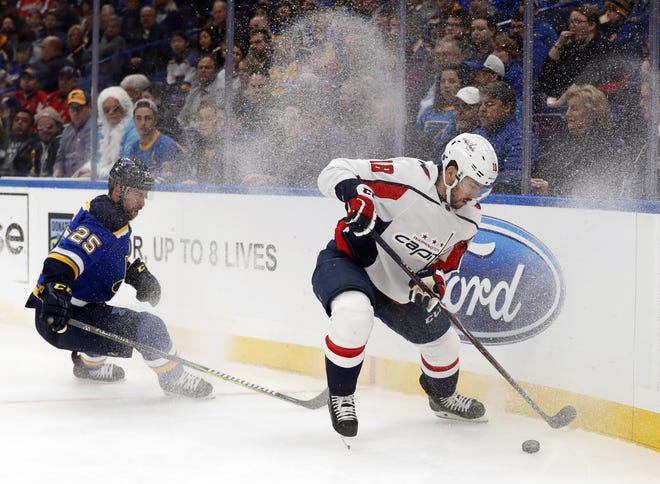 St. Louis Blues' Chris Butler and Washington Capitals' Chandler Stephenson chase after a loose puck along the boards during the first period of the Caps' 4-2 win on Monday in St. Louis. [Jeff Roberson/The Associated Press]