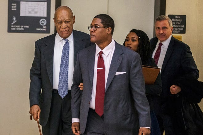 Bill Cosby, left, holds on tight to Andrew Wyatt as they make their way at the Montgomery County Courthouse during jury selection in his sexual assault retrial Tuesday, April 3, 2018, in Norristown, Pa. (Michael Bryant/The Philadelphia Inquirer via AP, Pool)