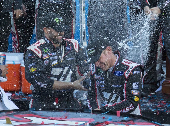 Clint Bowyer, right, celebrates with his crew after winning a NASCAR Cup Series auto race at Martinsville Speedway in Martinsville, Va., Monday, March 26, 2018. (AP Photo/Matt Bell)