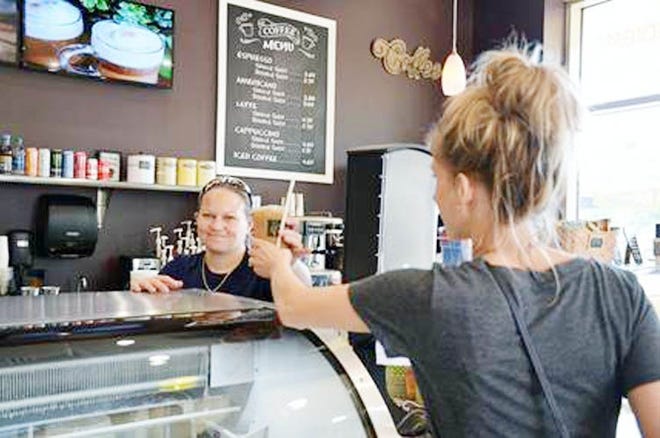 Employee Leah Kirchner makes a coffee latte for customer Denean Bross. [CONTRIBUTED PHOTO]