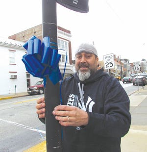 Bob Spessard tied blue ribbons around parking meters and poles in downtown Greencastle Tuesday and Wednesday to raise awareness about child abuse. He and his wife, Michelle, founded Blue Ribbons 4 Justice following the death of their grandson in 2007. SHAWN HARDY/ECHO PILOT.