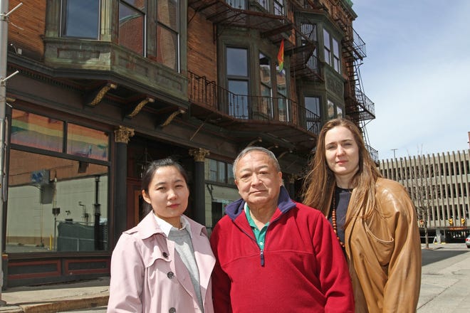 Angela Yuan-Feng, left, and Julieanne Fontana with James K. Chin, who was part of the Providence Chinese community as a boy, stand in front of the Chinese Merchants Building on Snow Street. [The Providence Journal / Steve Szydlowski]