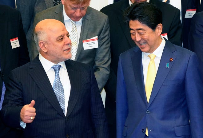 Iraq's Prime Minister Haider al-Abadi, left, talks with Japanese Prime Minister Shinzo Abe at the opening ceremony of the expert level of the international conference on Iraqi economic development in Tokyo, Thursday, April 5, 2018. (AP Photo/Shizuo Kambayashi)