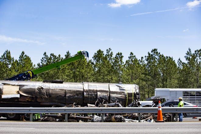 Workers block the left lane of traffic while getting ready to tow a tanker truck that caught fire Friday. [Lauren Bacho/Gainesville Sun]