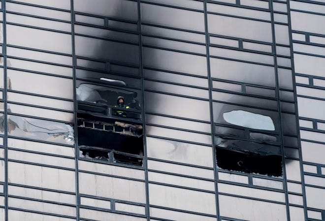 A firefighter looks out from the window of a fire damaged apartment in Trump Tower in New York on Saturday, April 7, 2018. (AP Photo/Craig Ruttle)