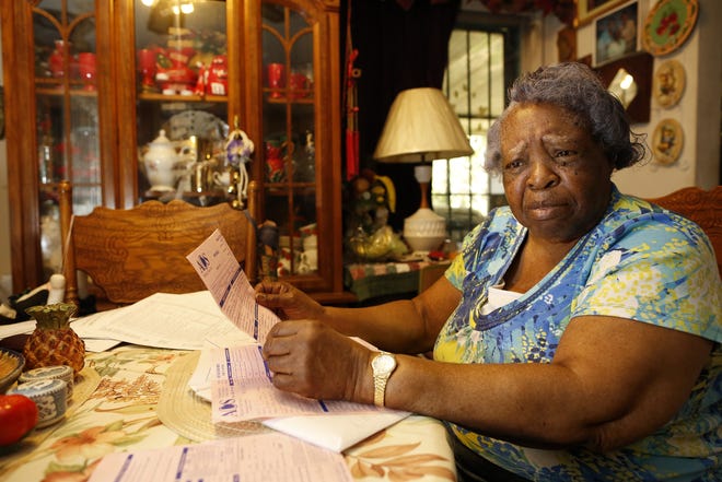 Fannie McCray, who says she feels deceived by the Property Assessed Clean Energy finance program, sits at her dinning room table with some of the paperwork from the contractor. Several Alachua County homeowners say they did not realize the cost of their home improvements would be tacked onto their mortgage and property tax bills. [Brad McClenny/The Gainesville Sun]
