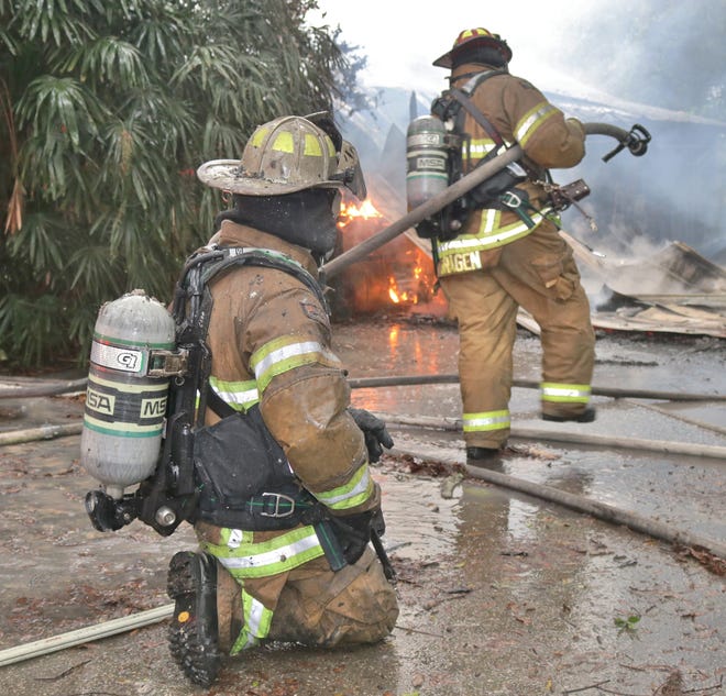 Marion County firefighters battle a blaze Tuesday at a house in the 5000 block of SE Maricamp Road. [Austin Miller/Staff photo]