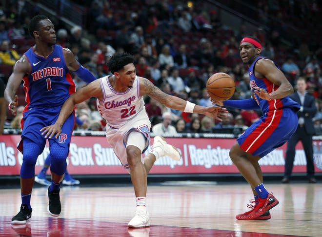 Chicago Bulls guard Cameron Payne (22) has the ball stripped by Detroit Pistons guard Langston Galloway (9) and guard Reggie Jackson (1) during the second half of an NBA basketball game in Chicago, Wednesday, April 11, 2018. (AP Photo/Jeff Haynes)