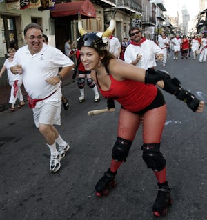 A member of the Big Easy Rollergirls roller derby league chases runners during the Running of the Bulls in the French Quarter of New Orleans on Saturday, July 12, 2008. The Peoria Prowlers roller derby team will do something similiar Saturday in Peoria Heights. (AP Photo/Pat Semansky)