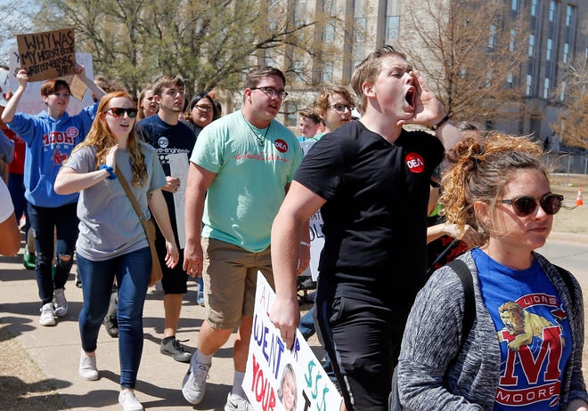 People, including teachers, students and parents from Moore Public Schools, march on the south side of the state Capitol on the 11th day of a walkout by Oklahoma teachers in Oklahoma City, Thursday, April 12, 2018. The Moore superintendent opened schools and ended the district's participation in the walkout on Thursday. Photo by Nate Billings, The Oklahoman