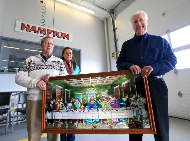 Patrick Greenish, Lisa Parker and Paul Nicholson of Hampton St. Vincent de Paul hold a glass painting replica of The Last Supper. The artwork was found still hanging among destroyed equipment and decorations a day after a fire at Hampton Beach that destroyed a building housing a soup kitchen and apartments. It will be placed at the Hampton Beach fire station while the soup kitchen operates there temporarily. [Ioanna Raptis/Seacoastonline]