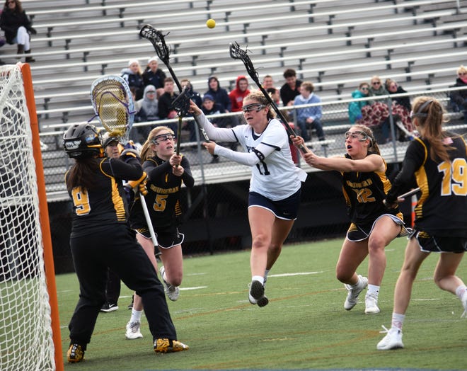 Exeter senior Jen Rogers, center, looks to get a shot off as she makes a run at the Souhegan net during Wednesday's Division I girls lacrosse game at Eustis Field. [Ryan O'Leary/Seacoastonline]