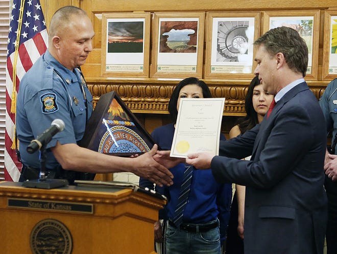 Gov. Jeff Colyer presents Kansas Highway Patrol Trooper Raul Carrillo, left, with the Governor's Award for Valor on Thursday at the Statehouse. Carrillo pulled a driver from a burning semi on Feb. 21 after a crash on the Kansas Turnpike in Butler County. [Thad Allton/The Capital-Journal]