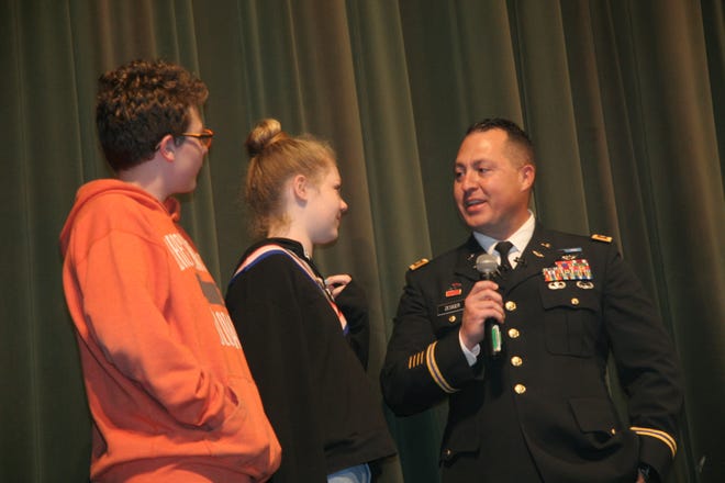 Zander Zesiger, from left, and Aspen Zesiger were surprised by the appearance of U.S. Army Maj. Brian Zesiger at Hutchison Middle School Friday. His children hadn't seen their father in more than a year due to his military service. [Ray Westbrook/A-J Media]