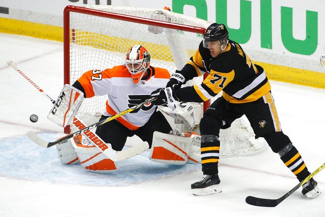 Pittsburgh Penguins' Evgeni Malkin (71) cannot get his stick on a puck in front of Philadelphia Flyers goaltender Brian Elliott (37) during the first period in Game 2 of an NHL first-round hockey playoff series in Pittsburgh, Friday, April 13, 2018. (AP Photo/Gene J. Puskar)