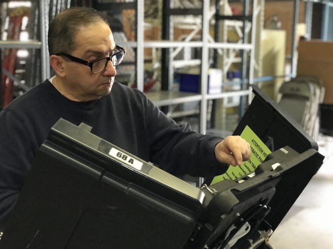Beaver County Elections Bureau clerk Anthony Harb prepares one of the county's 457 voting machines for the May primary election Friday at the county Public Works Department building in Patterson Township. [Tom Davidson/BCT staff]